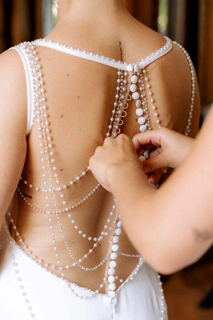 Knöpfen des Brautkleides am Rücken Hochzeitsplanung in Konstanz