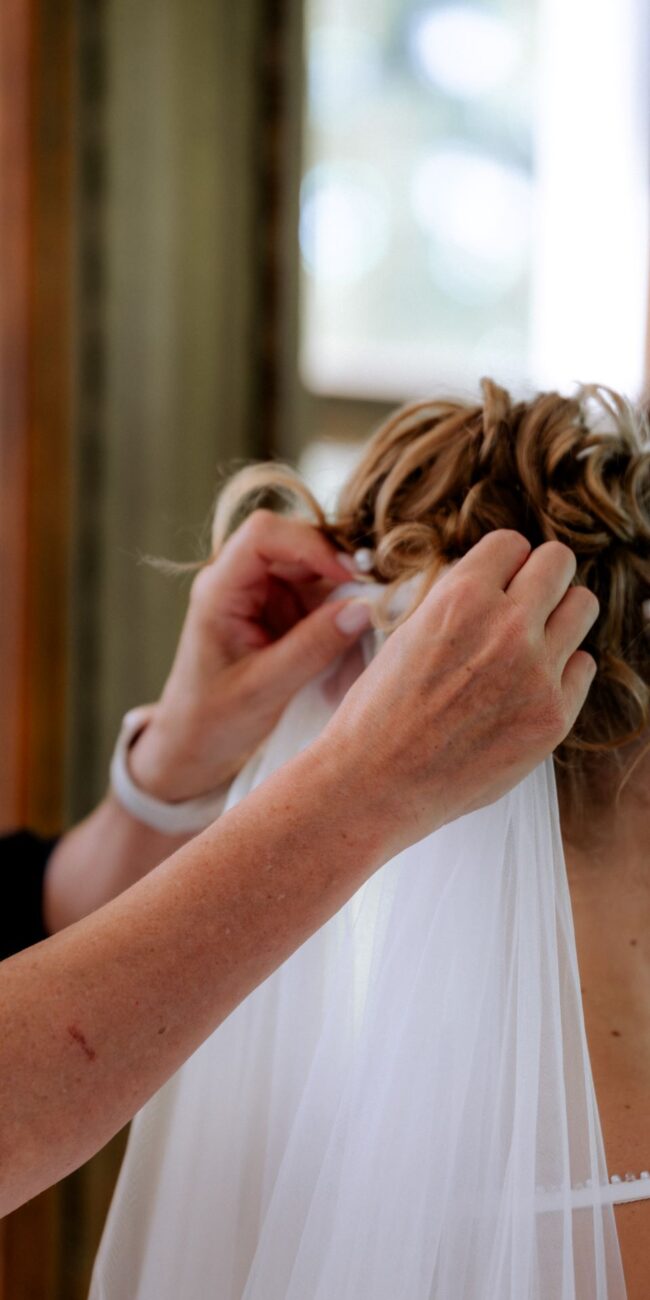 Schleier wird der Braut in die Haare gesteckt Hochzeitsplanung in Konstanz