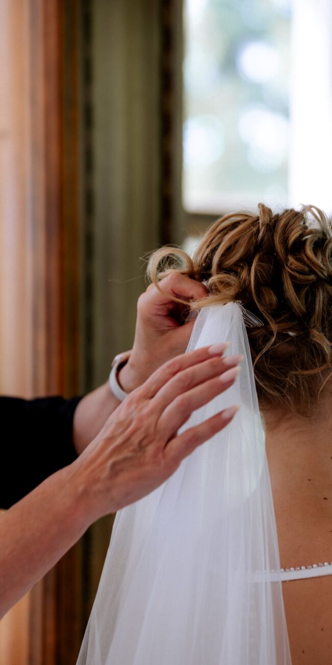 Schleier wird der Braut in die Haare gesteckt Hochzeitsplanung in Konstanz